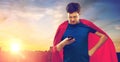 Man in red superhero cape using smartphone Royalty Free Stock Photo