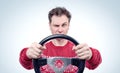 Man in red sweater driving a car with a steering wheel, drive concept Royalty Free Stock Photo