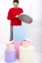 A man in a red sweatshirt takes out a gift box. birthday surprise. Christmas multicolored gift boxes on a white background.