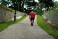 Man in a red t-shirt walking in a green public park in Kepong, Kuala Lumpur, Malaysia.