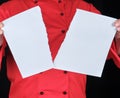 Man in a red uniform holds a white sheet of paper torn in half