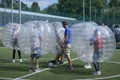 Man keeping ball in the center of a football field by his leg, before beginning of bubble football