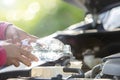 Man refill water to tank of car radiator and checking up the engine before start the trip. Car maintenance or check up concept Royalty Free Stock Photo