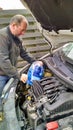 Man refilling windshield washing fluid in car Royalty Free Stock Photo