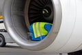 A man in a reflective vest. Technician sits in a turbine and checks the plane's engine before flying. Aviation