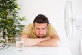 Man refreshing in front of air electric fan Royalty Free Stock Photo