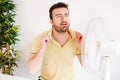 Man refreshing in front of air electric fan Royalty Free Stock Photo