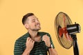 Man refreshing from heat in front of fan Royalty Free Stock Photo