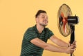 Man refreshing from heat in front of fan Royalty Free Stock Photo