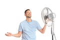 Man refreshing from heat in front of fan Royalty Free Stock Photo