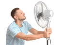 Man refreshing from heat in front of fan Royalty Free Stock Photo