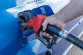 A man refuels a car. Refueling gun