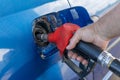 A man refuels a car. Refueling gun