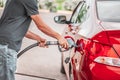 A man refuels a red car on a sunny day Royalty Free Stock Photo