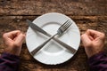 Man refuses to eat spoon and fork on a plate stacked in the shape of a cross Royalty Free Stock Photo