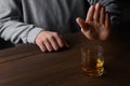 Man refusing to drink whiskey at wooden table, closeup. Alcohol addiction Royalty Free Stock Photo