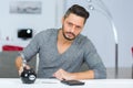 man regretfully poised to smash open piggy bank