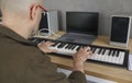 Man is rehearsing while playing on compact modern synthesizer in his home music studio. Royalty Free Stock Photo