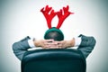 Man with a reindeer antlers headband in his office chair