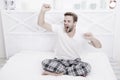 Man relax in bed. perfect morning. yawn and stretch in the morning. feeling cosy and comfortable. Menswear pajamas Royalty Free Stock Photo