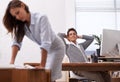 Man, relax and break on computer at the office looking at woman or colleague leaning on desk. Male person or employee Royalty Free Stock Photo