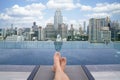 A man relax and sleeping on hotel rooftop swimming pool with Bangkok city