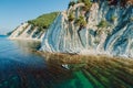 Man relax on stand up paddle board in sea with incredible landscape. Aerial view