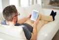 Man, relax and tablet screen in living room in home for social media, networking and reading news online. House, male Royalty Free Stock Photo