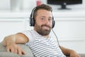 man relaxes with headphones and laptop on sofa Royalty Free Stock Photo