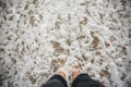 Man is relaxing barefoot at the beach. Guy`s legs in waves at the ocean side. Coastline in the clouds and sun. Summer vacation. Royalty Free Stock Photo