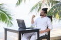 Man relaxing on the beach with laptop, freelancer show win Royalty Free Stock Photo