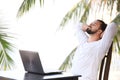 Man relaxing on the beach with laptop, freelancer workplace, dream job