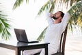 Man relaxing on the beach with laptop, freelancer workplace, dream job