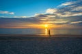 Man relaxing on the beach at sunrise, beautiful cloudy sky Royalty Free Stock Photo