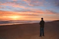 Man relaxing on beach at sunrise.