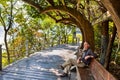 Man relaxing on bench under Chinese pergola