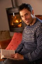 Man Relaxing With Book By Cosy Log Fire Royalty Free Stock Photo