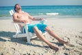 Man relaxing on deck chair at the beach Royalty Free Stock Photo