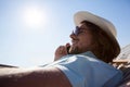 Man relaxing on hammock and talking on mobile phone on the beach Royalty Free Stock Photo