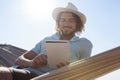 Man relaxing on hammock and using digital tablet on the beach Royalty Free Stock Photo