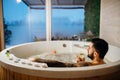 Man relaxing at home in the hot tub bath ritual with a glass of wine.Spa day moment in bathroom indoors jacuzzi tub.Leisure