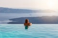 Man relaxing in infinity swimming pool, looking at the sea view Royalty Free Stock Photo