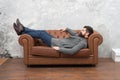 Man relaxing on luxurious leather couch, furniture store concept
