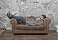 Man relaxing on luxurious leather couch, thoughtful mood concept
