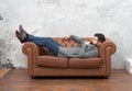 Man relaxing on luxurious leather couch, thoughtful mood concept