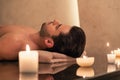 Man relaxing on massage table at Asian spa and wellness center Royalty Free Stock Photo