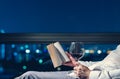 The man relaxing in the room reading book with a glass of red wine Royalty Free Stock Photo