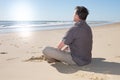 man relaxing sit on sand by the sea on sunny day Royalty Free Stock Photo