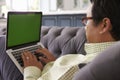 Man Relaxing On Sofa At Home Using Green Screen Laptop Royalty Free Stock Photo