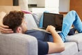 Man Relaxing On Sofa With Laptop In New Home Royalty Free Stock Photo